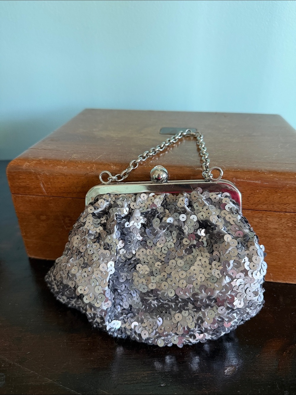 United Colors of Bennetton silver, sequin clutch with clasp closure.